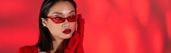 Портрет Азиатки Модных Солнцезащитных Очках Перчатках Красном Абстрактном Фоне Баннер — стоковое фото