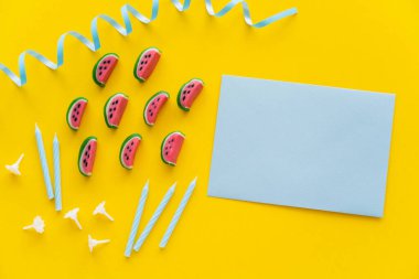 Top view of candies near festive candles and greeting card on yellow background  clipart