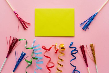 Yılanbalığının yanındaki boş tebrik kartının en üst görüntüsü ve pembe arka planda süslemeli pipetler içmek 
