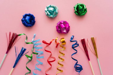 Hediye manzarası yılan gibi kıvrılıyor ve pembe arka planda pipet içiyor. 