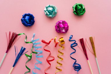 Top view of gift bows near serpentine and drinking straws on pink background  clipart