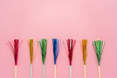 Top view of drinking straws with colorful tinsel on pink background with copy space clipart