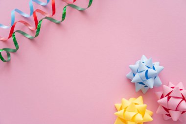 Rengarenk yılanın üst görüntüsü ve pembe arka planda hediye yayları 