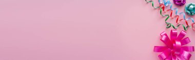 Pembe arka planda renkli yılan ve hediye yay manzarası, afiş 
