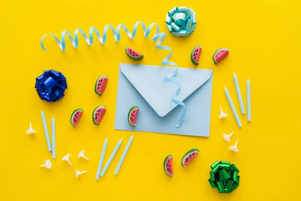 stock image Top view of festive candles near sweets and envelope on yellow background 