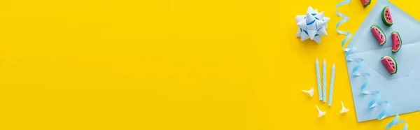 Hediye Yayının Yanındaki Mavi Zarfın Üzerindeki Şekerler Sarı Arkaplanda Şenlikli — Stok fotoğraf