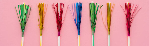 Top view of drinking straws with colorful tinsel on pink background, banner 