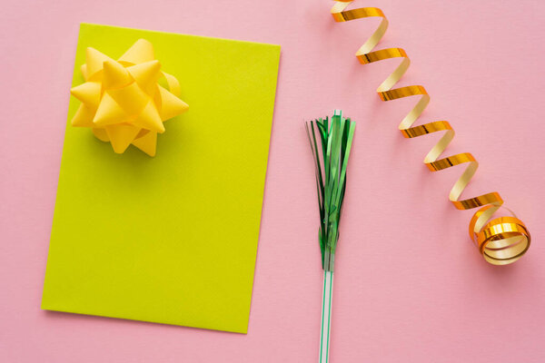 Вид на поздравительную открытку рядом со змеиной и питьевой соломой на розовом фоне 