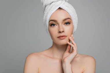 Çıplak omuzları ve kafasında havlusu olan genç kadın gri renkte izole edilmiş. 