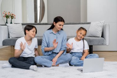 Gülümseyen Asyalı çocuklar ve aileleri evde bilgisayar başında 