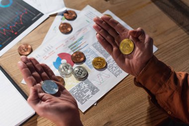 KYIV, UKRAINE - 17 Kasım 2022: Gazetelerin yanında gümüş ve altın bitmadeni paralar bulunan işadamlarının üst görünümü