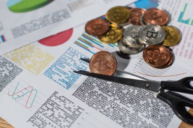 KYIV, UKRAINE - 17 Kasım 2022: makas ve kağıtların yanında iş bilgileri ve grafiklerle gümüş ve altın bitcoin 