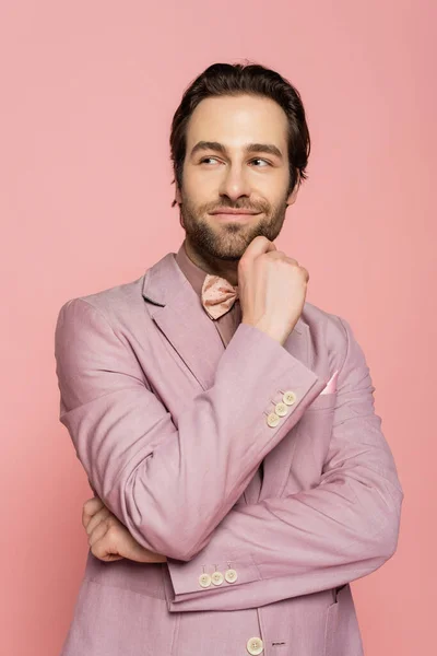 Portrait of bearded host of event looking away isolated on pink