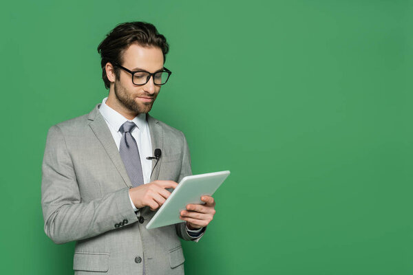 журналист в очках и костюме с помощью цифрового планшета изолированы на зеленый 