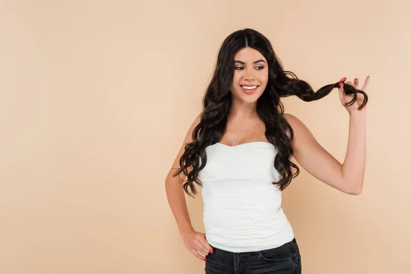 Güzel Esmer Kadın Bej Renkte Poz Verirken Dalgalı Saçlara Dokunuyor — Stok fotoğraf