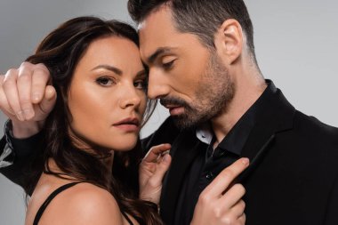 Esmer kadın ve sakallı adamın portresi gri yolda izole edilmiş. 