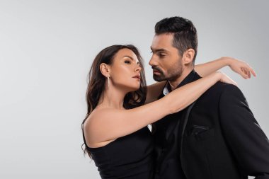 Hayalperest kadın, siyah takım elbiseli sakallı adama sarılıyor. 