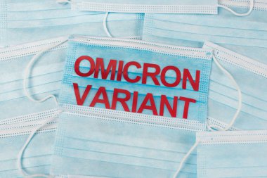 Top view of medical masks with red omicron variant lettering 