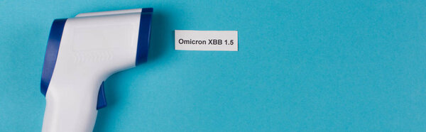 Top view of omicron xbb lettering near pyrometer on blue background, banner 