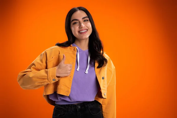 stock image Cheerful young woman showing like sign isolated on orange