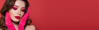 sensual young woman in bright magenta color gloves posing isolated on pink, banner 