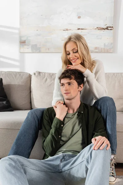 Young Blonde Woman White Sweater Hugging Curly Boyfriend Living Room — Stockfoto