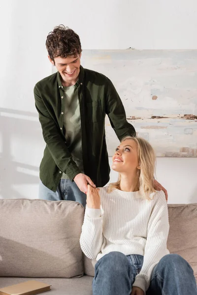 Curly Young Man Blonde Woman Holding Hands Living Room —  Fotos de Stock