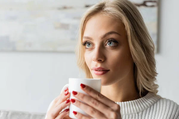 Dreamy Young Woman White Sweater Holding Cup Coffee Looking Away — Stockfoto