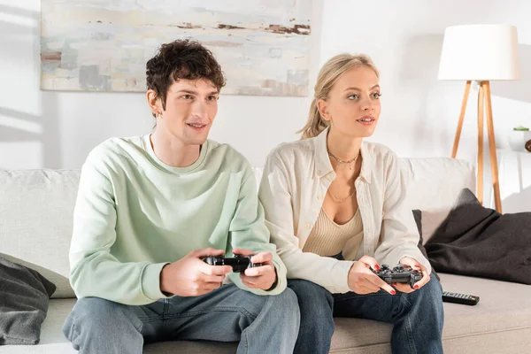 stock image KYIV, UKRAINE - OCTOBER 24, 2022: young couple playing video game at home 