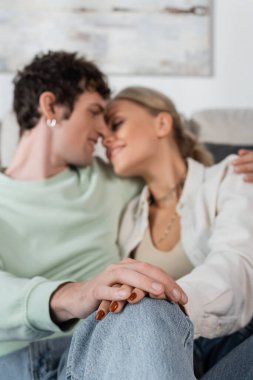 young couple hugging and holding hands on blurred background 