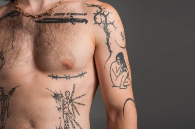 Cropped view of shirtless and tattooed man standing isolated on grey  clipart