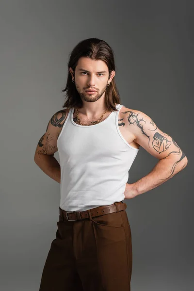 stock image Tattooed model in pants and white tank top isolated on grey 