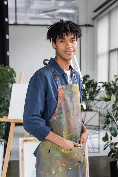stock image Young african american artist in dirty apron posing in studio 