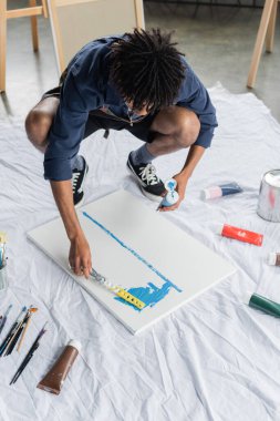 Önlüklü Afrikalı Amerikalı ressam. Stüdyoda spatulayla resim yapıyor. 