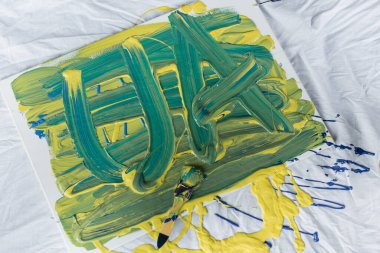 Top view of ua letters on canvas on cloth in workshop  clipart
