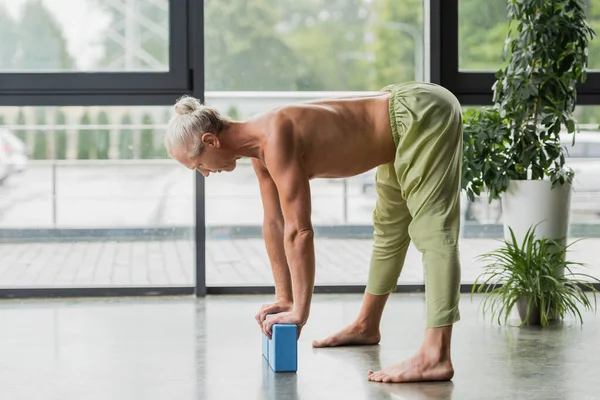 Yeşil Pantolonlu Üstsüz Adam Stüdyoda Yere Yoga Köpüğü Blokları Koyuyor — Stok fotoğraf