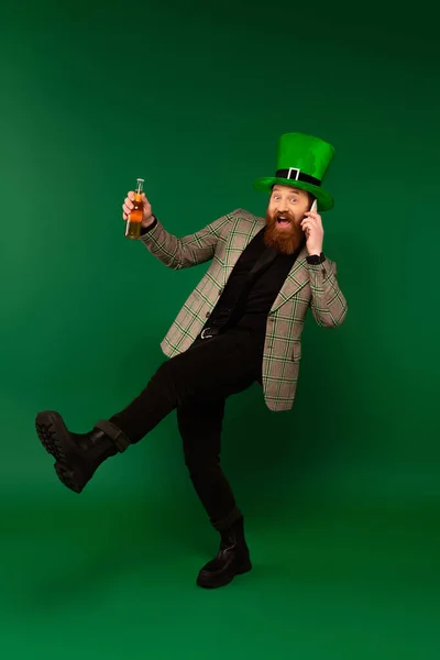 Excited Bearded Man Hat Holding Beer Talking Smartphone Green Background — Stockfoto