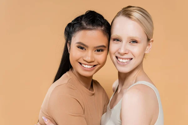 stock image cheerful multicultural women in underwear looking at camera isolated on beige