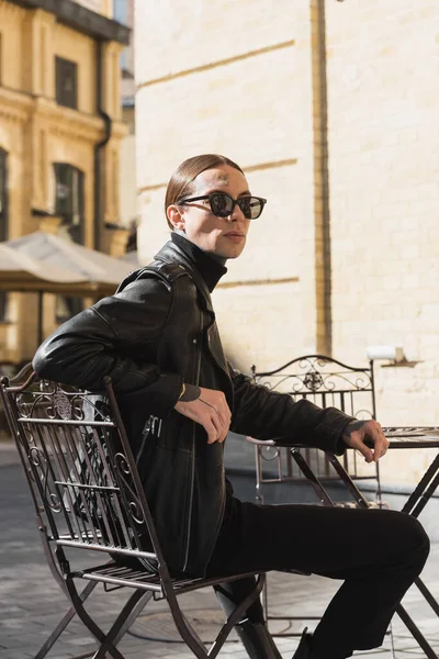 Tattooed Young Man Stylish Sunglasses Black Leather Jacket Sitting Outdoor — Zdjęcie stockowe