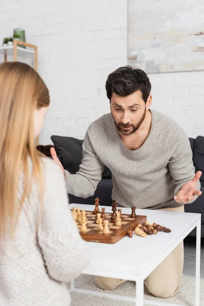 Confused Bearded Man Showing Shrug Gesture While Playing Chess Preteen —  Fotos de Stock