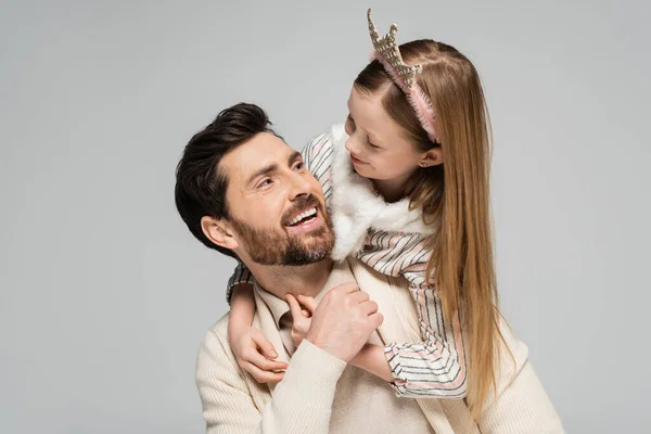 happy kid in crown hugging joyful father with beard isolated on grey