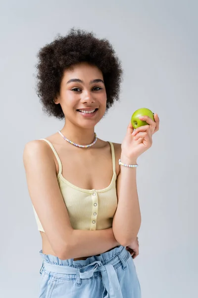 灰色で隔離されたリンゴを保持する上で肯定的なアフリカ系アメリカ人モデル — ストック写真