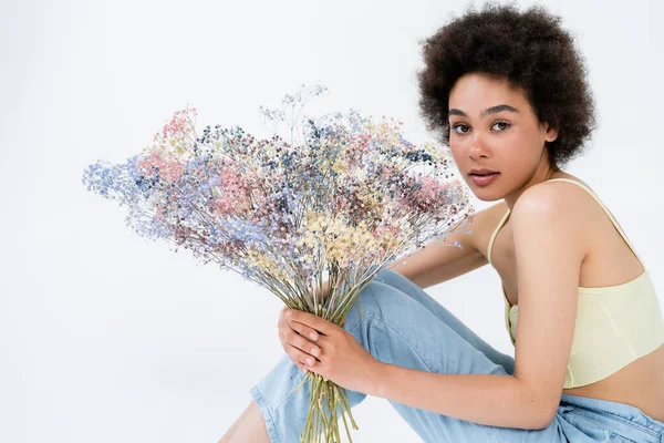 Νεαρή Αφροαμερικάνα Που Κρατάει Μωρουδίστικα Λουλούδια Και Κοιτάζει Την Κάμερα — Φωτογραφία Αρχείου