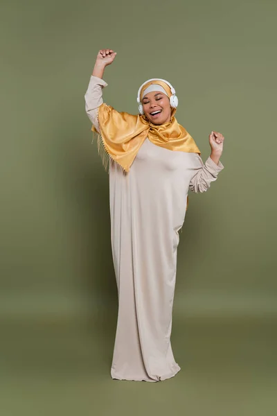 Повна Довжина Багаторасової Жінки Хіджабі Навушники Танцюють Зеленому Фоні — стокове фото