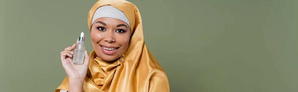 Multirasial Wanita Dalam Jilbab Emas Memegang Serum Terisolasi Pada Hijau — Stok Foto