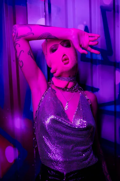 Соблазнительная Женщина Серебристом Топе Розовой Балаклаве Позирует Стены Граффити Фиолетовом — стоковое фото
