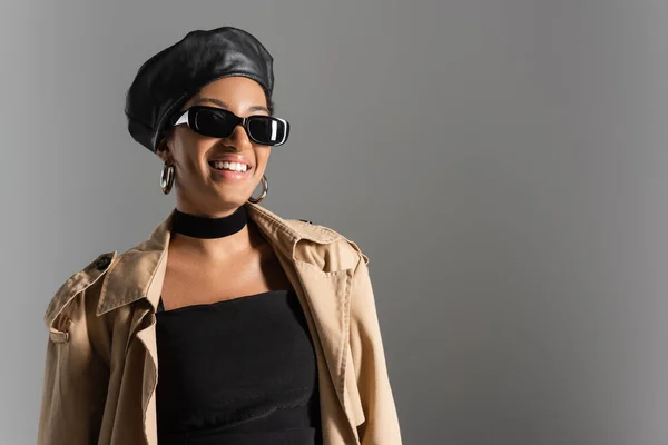 Усміхнена Афроамериканка Береті Тренч Пальто Стоїть Ізольовано Сірому — стокове фото
