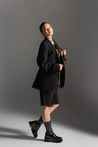 Модная Азиатская Модель Куртке Шортах Смотрящая Камеру Сером Фоне — стоковое фото