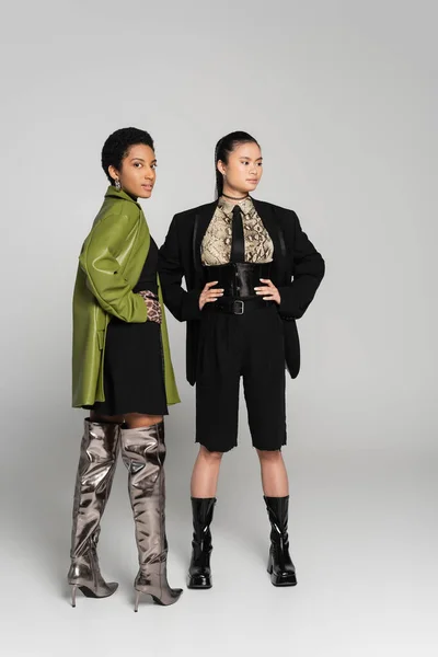 Stylish African American Woman Posing Asian Friend Jacket Grey Background — Stok Foto