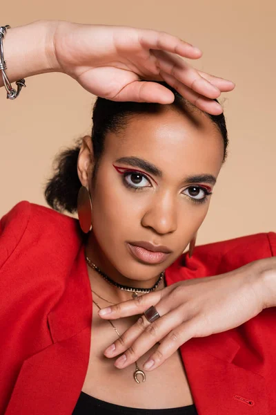 Parlak Kırmızı Ceketli Afro Amerikan Modelinin Bej Renkli Kameraya Bakarken — Stok fotoğraf